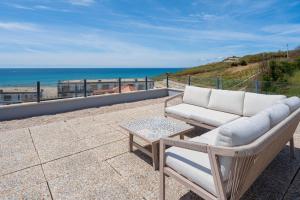 a couch and a table on a balcony with the ocean at Beach Villa with ocean view in Lourinhã +46 photos