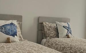 a bedroom with two beds with pillows at Vittorino house in Polignano a Mare