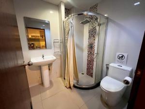 a bathroom with a shower and a toilet and a sink at The Pixel Sri Panwa, Phuket in Ban Ao Makham