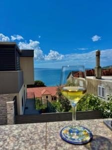 a glass of wine sitting on a table with a view at Apartments Adriatic Nest in Omiš