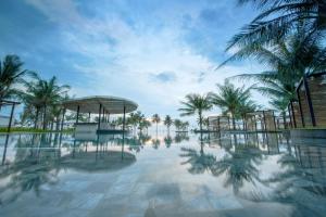 einen Pool im Resort mit Palmen in der Unterkunft SOL by Meliá Phu Quoc in Phu Quoc