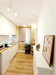 a kitchen with white cabinets and a counter top at Fiore Kampielo Apartment in Corfu