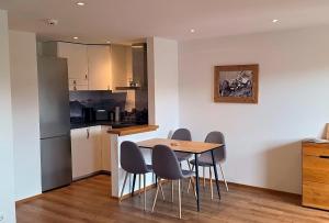 a kitchen and dining room with a table and chairs at Allgäuer Ferienwohnung mit Balkon, Bergblick und Wallbox in Rettenberg