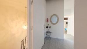 a white hallway with a mirror and a staircase at Maison M Bed and Breakfast in Alignan-du-Vent +18 photos