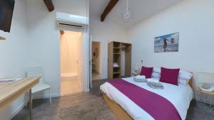 a bedroom with a large bed with purple pillows at Maison M Bed and Breakfast in Alignan-du-Vent
