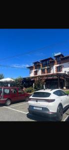 a white car is parked in a parking lot at hosteria de Boo in Boó de Piélagos