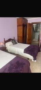 a bedroom with two beds and a cabinet at hosteria de Boo in Boó de Piélagos +5 photos