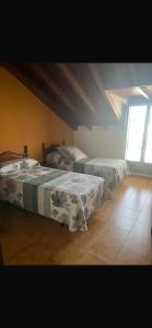 a bedroom with two beds and a window at hosteria de Boo in Boó de Piélagos