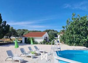 a resort with a pool and chairs and a house at MyStay - Monte dos Abrunhos in Vimieiro