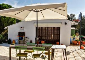 a patio with a table and a large umbrella at MyStay - Monte dos Abrunhos in Vimieiro