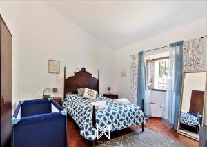 a bedroom with a bed with a blue and white comforter at MyStay - Monte dos Abrunhos in Vimieiro +38 photos
