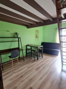 a room with a table and chairs and a couch at Chambre des baumes in Chablis