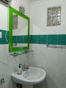 ein Badezimmer mit Waschbecken und Spiegel in der Unterkunft Jemi's House in Vibonati