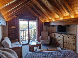a bedroom with a bed and a television and a balcony at Hotel Rural Irati selva de Irati in Jaurrieta