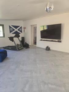 a living room with a flat screen tv and a gym at Chambre des baumes in Chablis