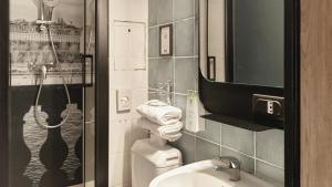 a bathroom with a toilet and a sink and a mirror at Campanile PRIME - Paris 15 Tour Eiffel in Paris +30 photos