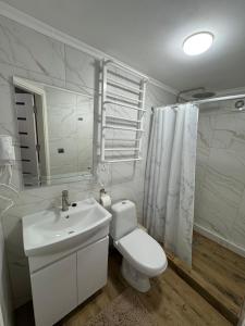 a white bathroom with a toilet and a sink at Vista Guest House in Yaremche +33 photos