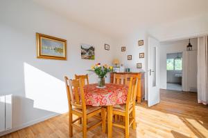 a kitchen and dining room with a table and chairs at L'Instant Arradon - Pointe & sentiers côtiers in Arradon