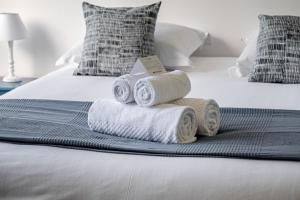 a pile of towels sitting on top of a bed at L'Instant Arradon - Pointe & sentiers côtiers in Arradon +3 photos