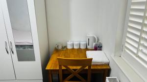 a wooden table with a chair in a room at Budget Stay In Luton 01 R in Luton +7 photos