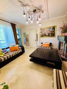 a living room with a couch and a table at Shin Boutique Hotel with Mini Golf Terrace in Buriaki