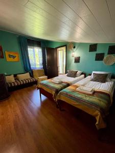 two beds in a room with green walls at Shin Boutique Hotel with Mini Golf Terrace in Buriaki