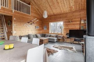 a living room with a table and a couch and a television at Tännstoppet - Tänndalen in Tänndalen