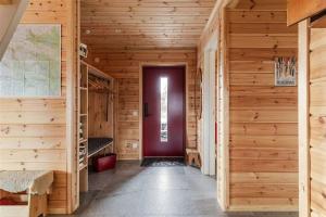 a hallway with wooden walls and a red door at Tännstoppet - Tänndalen in Tänndalen