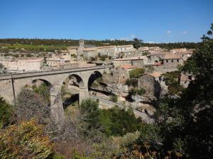 an old stone bridge over a city with buildings at Bergerie L'Occitane in La Caunette