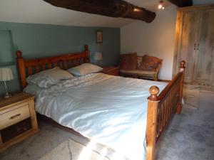 a bedroom with a large bed and a chair at Bergerie L'Occitane in La Caunette +17 photos