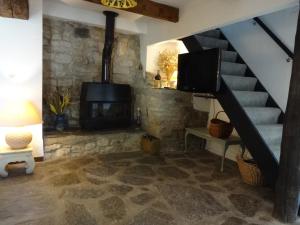 a living room with a staircase and a fireplace at Bergerie L'Occitane in La Caunette