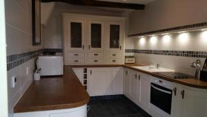 a kitchen with white cabinets and a sink at Bergerie L'Occitane in La Caunette
