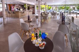 a restaurant with tables and chairs with drinks on them at GHT Sa Riera in Tossa de Mar
