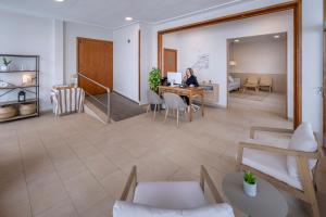 a woman sitting at a table in a room at Hotel GHT Simeon in Tossa de Mar +39 photos