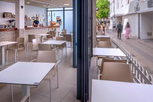 a row of tables and chairs in a restaurant at Hotel GHT Simeon in Tossa de Mar