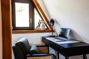 a desk with a laptop and a chair in a room at Galaxy6189 Guesthouse in Tapolca