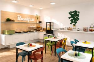 a restaurant with tables and chairs and a counter at SHOME Hotel Graz I Self-Check-In I Free Parking in Graz