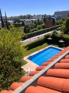 a swimming pool with orange lounge chairs next to it at Tomillaron House in Las Rozas de Madrid