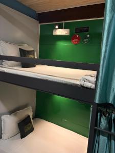 a room with two bunk beds with green walls at Forrest Hostels in Mumbai +13 photos