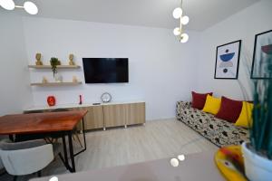 a living room with a couch and a tv at FLH - Brukenthal Studios - Old Town in Sibiu
