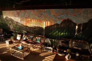 a room with two chairs and a mural on the wall at Forrest Hostels in Mumbai