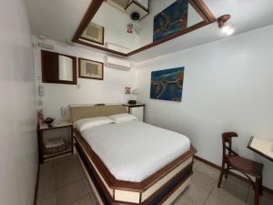 a small bedroom with a bed and a desk at Lemonte Motel in Brusque