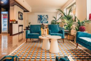 a lobby with blue chairs and a table at Garden Hotel Michelangelo in Mestre