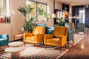 a waiting room with chairs and tables and plants at Garden Hotel Michelangelo in Mestre
