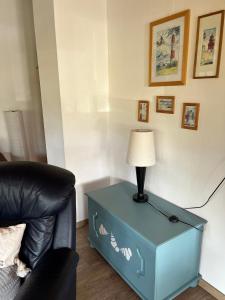 a blue end table with a lamp on it next to a chair at Ferienwohnung Raschke in Fehmarnsund