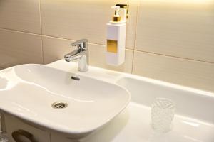 a bathroom with a white sink and a bath tub at FLH - Brukenthal Studios - Old Town in Sibiu +72 photos