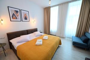 a hotel room with a bed and a blue chair at FLH - Brukenthal Studios - Old Town in Sibiu