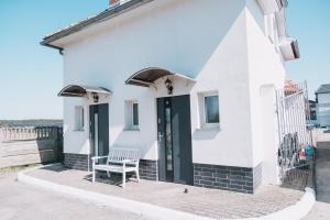 a white house with a bench in front of it at Noclegi Witnica in Witnica
