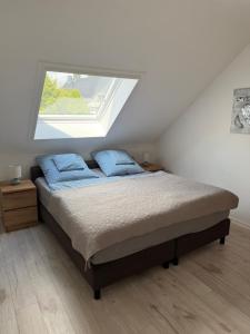a bedroom with a bed with two blue pillows at Panorama-Blick Brüggen in Brüggen