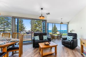 a living room with a table and chairs and a view of the ocean at Bonnies of Beachport in Beachport